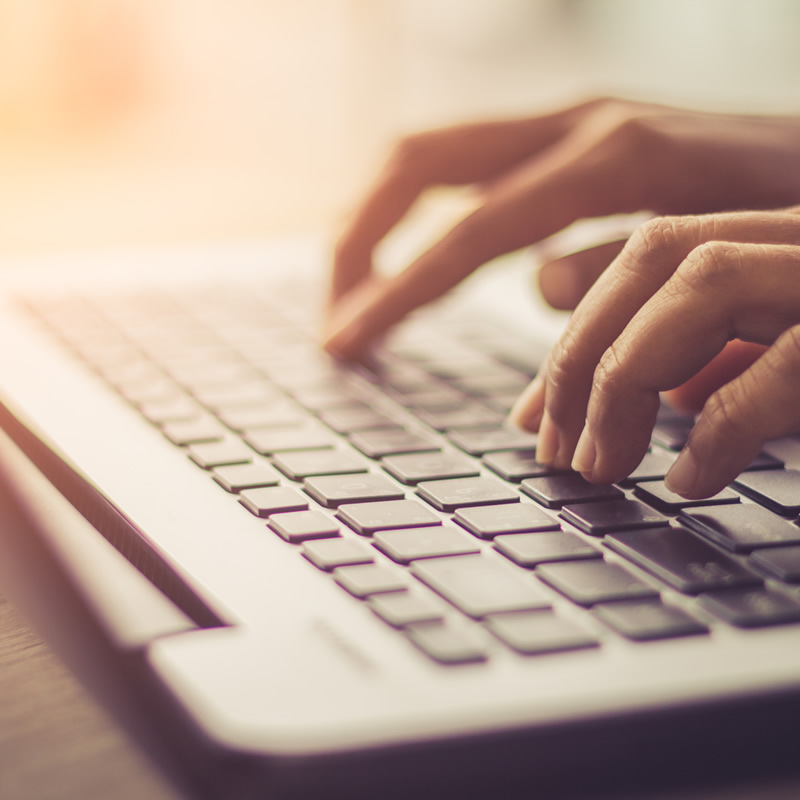 Someone's hands typing on a laptop keyboard